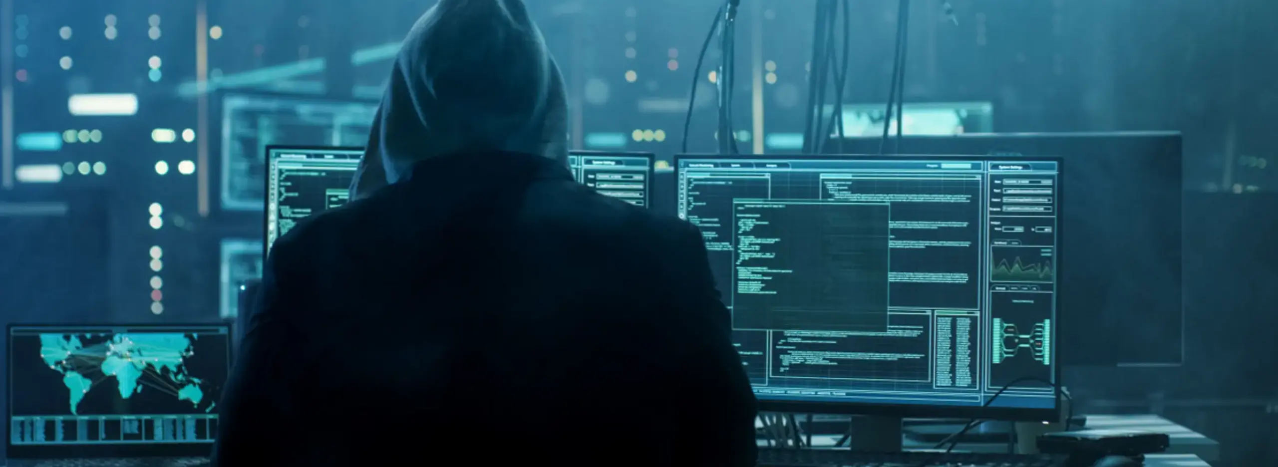 Hacker sitting in front of a computer on desktop view.